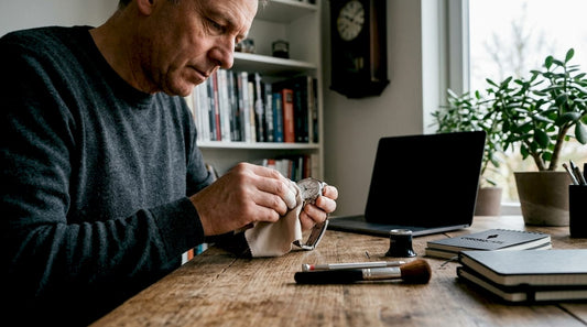 Person cleaning luxury watch at home table