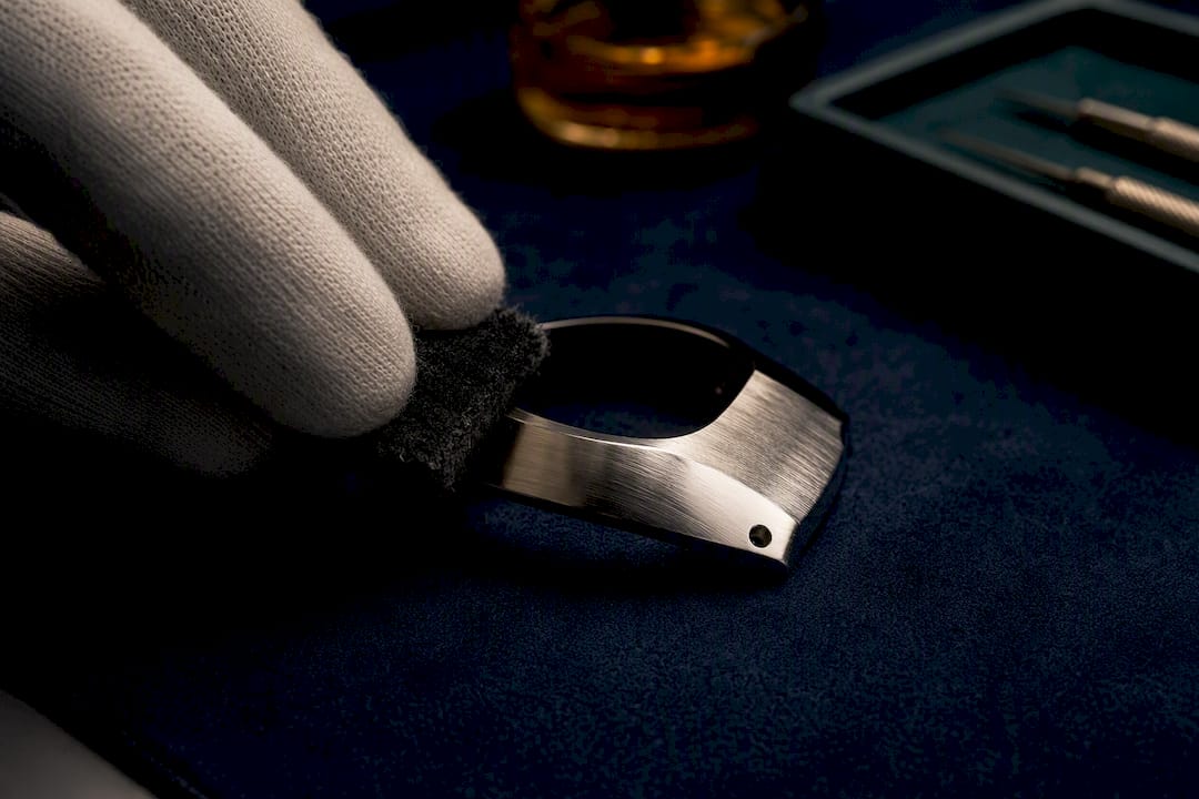 Gloved hand blending scratches on watch case