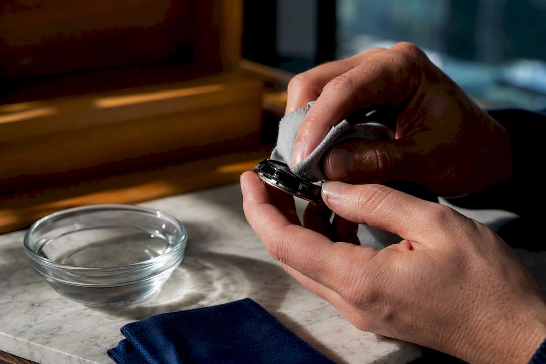 Hands cleaning a ceramic watch case edge