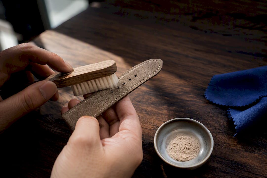 Brushing an anonymous suede watch strap
