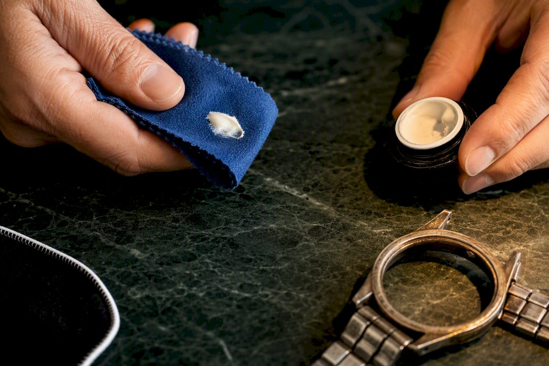 Polishing cloth and cream beside watch case