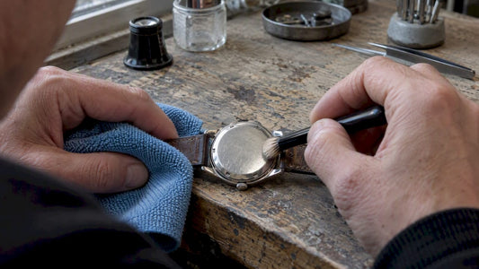 Collector cleaning a sealed vintage watch caseback